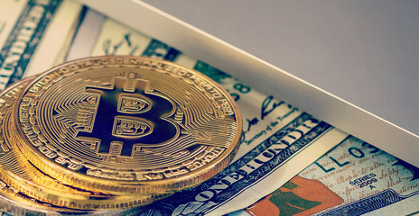 Fototapeta na wymiar Bitcoin golden coins on a dollar banknotes office background white laptop mobile