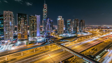 Buildings of Jumeirah Lakes Towers with traffic on the road night timelapse.