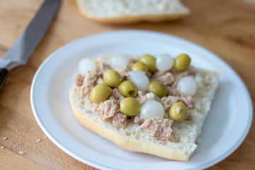 Sandwich with tuna, olives and small onions in vinegar