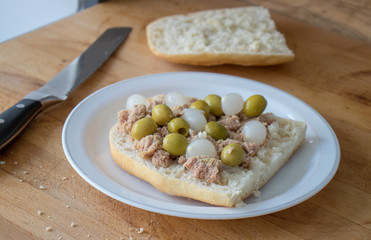 Sandwich with tuna, olives and small onions in vinegar