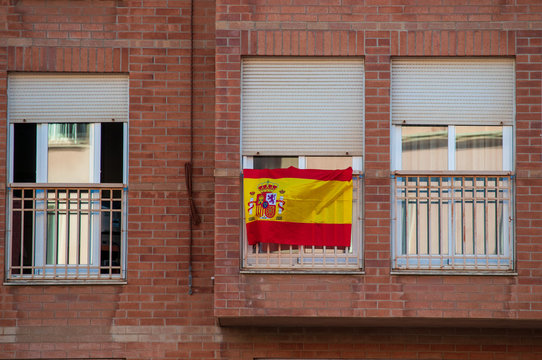 Flag of Spain hanging on the balcony of a house as a symbol of support for Spanish nationalism in the face of Catalan independence