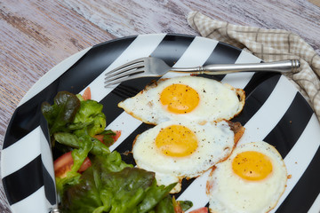 Healthy Breakfast in the morning. scrambled eggs with fresh salad and vegetables. a plate on an old, bright, shabby table . vertical view, close-up.
