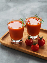 Delicious cold Gazpacho soup in glasses on gray background with space for text.