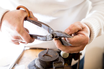 Złotnik w pracowni jubilerskiej wykonuje biżuterię.