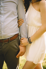 Woman lovingly holds her husband's arm in the evening sun