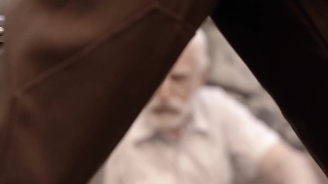 Angry NKVD soldier interrogates a miserable, bearded, gray-haired old man on the street, a soldier mocks his grandfather, tortures of the NKVD, the old man fears for his life, wartime