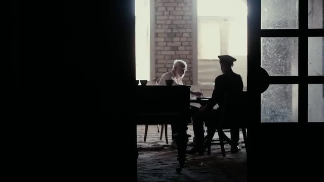 Soldier of the Russian army interrogates a suspect, an elderly man with a beard, under pain of execution, signs papers, the injustice of the NKVD, cynicism of the soldiers, the cruelty of the USSR