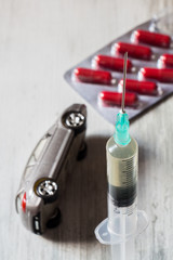 Driving under the influence of drugs. Pills, syringe and overturned car