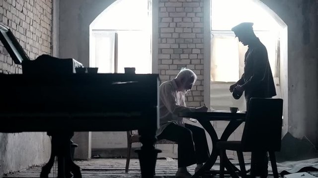 Soldier of the Russian army interrogates a suspect, an elderly man with a beard, under pain of execution, signs papers, the injustice of the NKVD, cynicism of the soldiers, the cruelty of the USSR