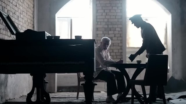 Soldier of the Russian army interrogates a suspect, an elderly man with a beard, under pain of execution, signs papers, the injustice of the NKVD, cynicism of the soldiers, the cruelty of the USSR