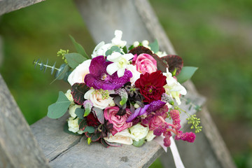 Bridal bouquet placed on an old wooden staircase by the bride