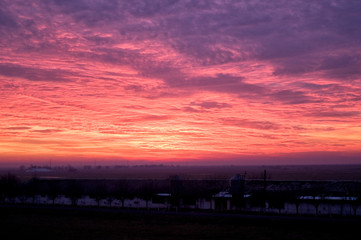 Fototapeta premium A dramatic purple pink and orange sunset with wispy clouds.