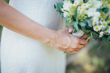 Obraz na płótnie Canvas bride holding flower bouquet close uo