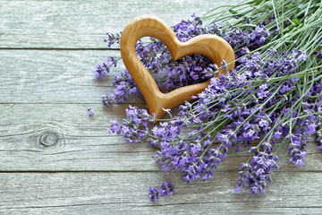 Lavender flowers  with heart 
on wooden background 