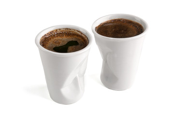 Crumpled ceramic coffee cups as plastic one time cup isolated on white background. Funny white ceramic coffee cups.