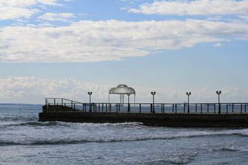 View of a pier with a wedding gazebo, the sky and the Mediterranean sea from the Limassol seafront in December