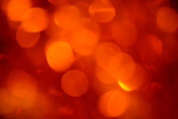 Obraz premium Bokeh. Holiday background. Christmas lights. Glitter. Defocused sparkles. New Year backdrop. Festive wallpaper. Blinks. Carnival. Bokeh retro style photo. Orange.