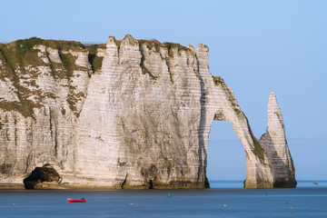 Fototapeta na wymiar Chalk cliffs of Etretat with the natural arch Porte d'Aval and the stone needle called L'Aiguille