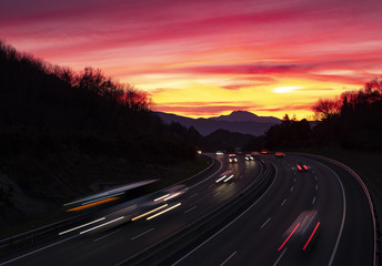 Car lights at sunset driving at high speed on the highway, San Sebastian, Euskadi