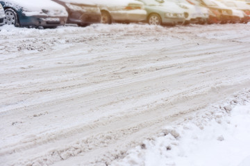 snowy dirty heavy road, cars parked background