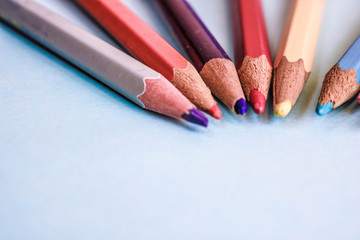Beautiful bright colored wooden colored sharpening pencils for drawing. Flat lay and copy space on blue background