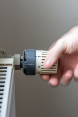 Male hand changing temperature on radiator