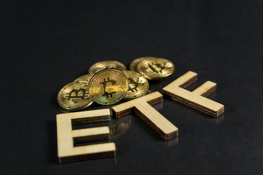 Bitcoin coin with ETF text Put on wooden floor, Concept Entering the Digital Money Fund.