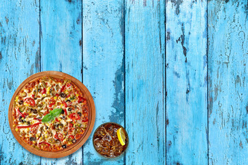 Pizza with Mozzarella, halved Cherry Tomatoes, Capers, Spices and Fresh Basil. Italian pizza. Home made food on vintage or grungy background.