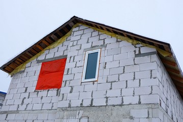 part of an unfinished white brick house with windows against the sky