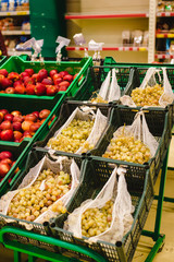 Variety of apples, oranges and grapes in boxes on city market