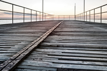 Empty old pier at sunset in the evening on the sea