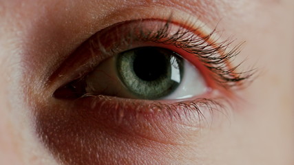 close up macro green eye blinking looking curious light reflecting on iris