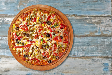 Supreme Pizza on grungy wooden background.