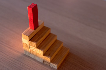 success concept with wooden pieces triumph and reach the highest