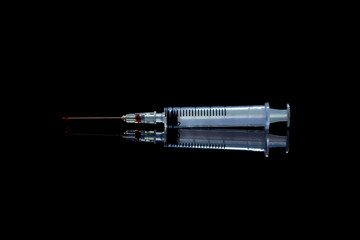 Syringe with a red droplet on the needle.Social advertising