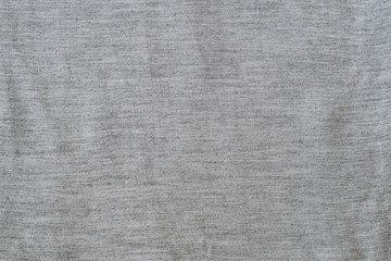 Solid background from a gray textured fabric. Close-up.