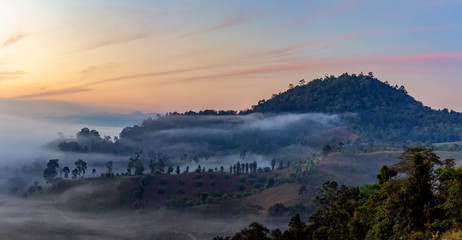 Mountain and foggy at morning time with orange sky, beautiful landscape in the thailand