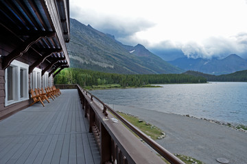 Old historic building structure on a clear lake in Glacier National Park.