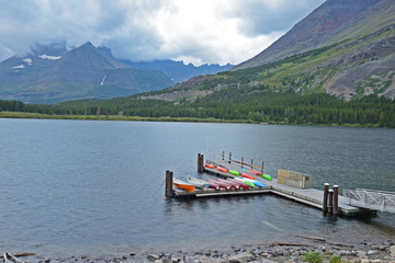 Fototapeta na wymiar Canoe dock on a blue lake in Glacier National Park.