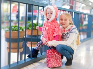 Kids doing shopping in the mall , shopping center .     