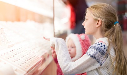 Kids doing shopping in the mall , shopping center .     