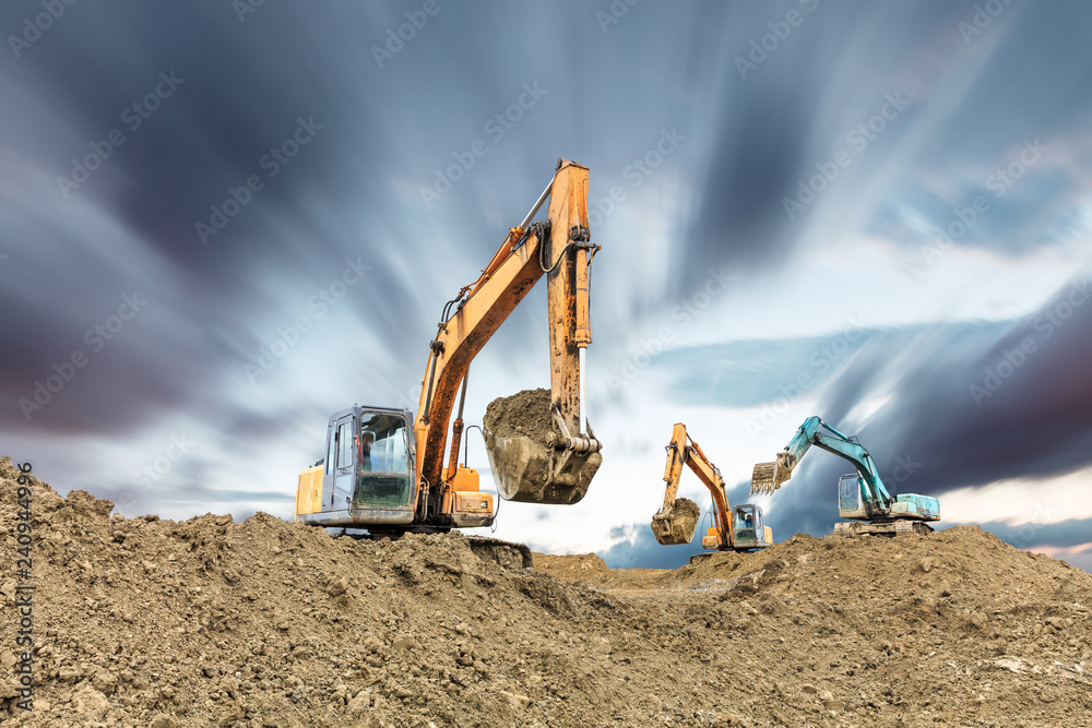 Wall mural excavator working on construction site in cloudy day