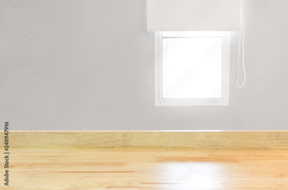 Poster Blank wood table top view and blur window on grey wall from office with sunlight. Modern room for product display or design advertising layout.
