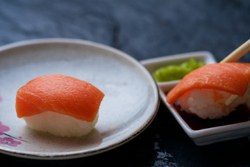 Dipping a salmon sushi in the soy sauce