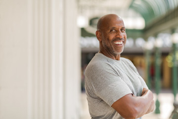 Happy mature African American man smiling outside.