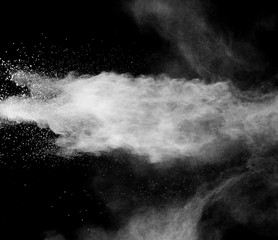 Freeze motion of white dust particles on black background. White powder explosion.
