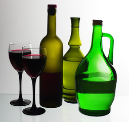 Bottles of wine and a glass of wine on a light background