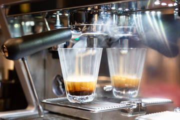 Close-up of espresso pouring from coffee machine at coffee shop