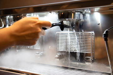 Barista cleaning cofee machine at coffee shop