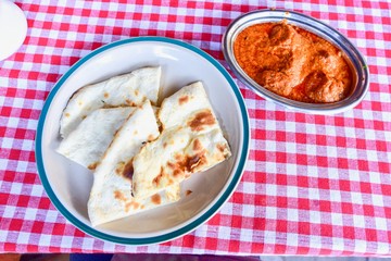 Top View of Chicken Tikka Masala with Indian Style Naan Breads